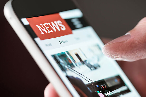 Mobile news application in smartphone. Person browsing latest articles on the internet. 